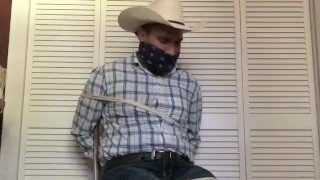 Cowboy gekneveld en vastgebonden aan een keukenstoel