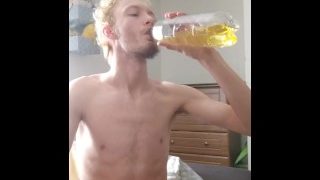 高个瘦的青少年在瓶子里撒尿并喝掉它